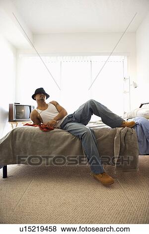Young Man Lying on Bed View Large Photo Image Stock Photo - Young Man Lying on Bed. Fotosearch