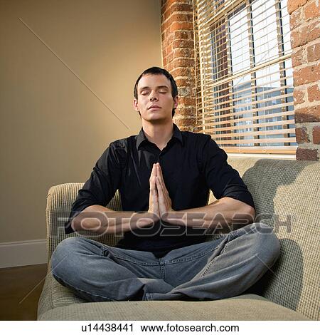 Stock Image - Young man meditating. Fotosearch