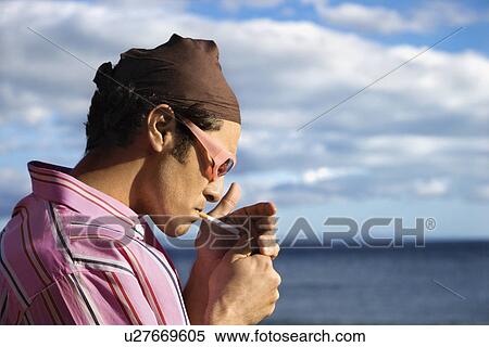 Young Man on Beach Lighting a Cigarette View Large Photo Image Stock Photography - Young Man on Beach Lighting a Cigarette. Fotosearch