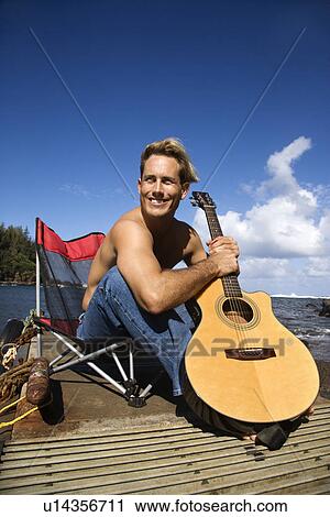 Young Man Sitting Lakeside Holding Guitar View Large Photo Image Stock Image - Young Man Sitting Lakeside Holding Guitar. Fotosearch