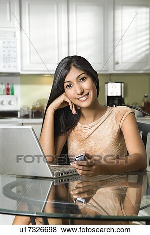 Stock Photo - Young Smiling Woman With Laptop and Cellphone. Fotosearch