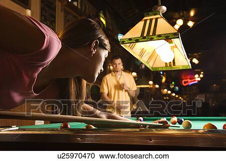 Stock Image - Young Woman Shooting Pool. Fotosearch