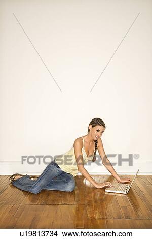 Picture - Young Woman Smiling Sitting on Floor with Laptop. Fotosearch