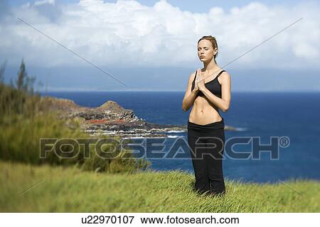Stock Photo - Young Woman Standing in Meditation. Fotosearch