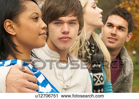 Stock Image - Close Up Of Group Of Four Teenage Friends In Autumn Woodland. Fotosearch