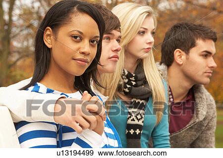 Stock Photo - Close Up Of Group Of Four Teenage Friends In Autumn Woodland. Fotosearch