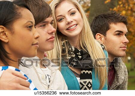 Stock Photograph - Close Up Of Group Of Four Teenage Friends In Autumn Woodland. Fotosearch
