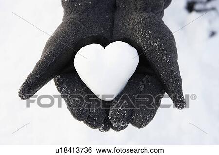 Stock Photograph - Close Up Of Hands Holding Heart Made Out Of Snow. Fotosearch
