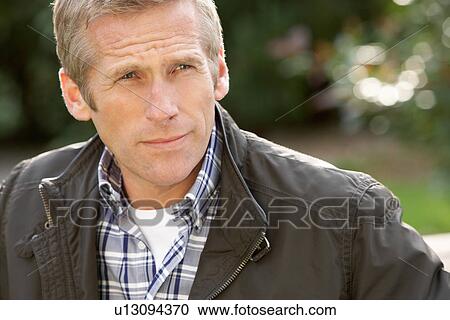 Stock Image - Close Up Portrait Of Man Standing Outside In Autumn Landscape. Fotosearch