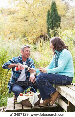Stock Photo - Couple Enjoying Picnic Outdoors In Autumn Woodland. Fotosearch