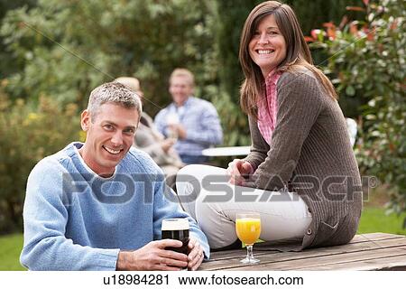 Couple Outdoors Enjoying Drink In Pub Garden View Large Photo Image Stock Image - Couple Outdoors Enjoying Drink In Pub Garden. Fotosearch