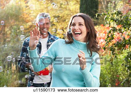 Couple Outdoors In Autumn Landscape With Bubble Machine View Large Photo Image Stock Image - Couple Outdoors In Autumn Landscape With Bubble Machine. Fotosearch