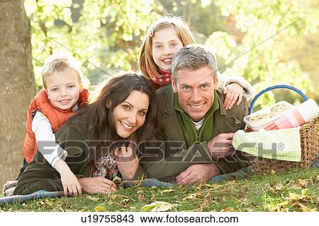 Stock Image - Family Group Relaxing Outdoors In Autumn Landscape. Fotosearch