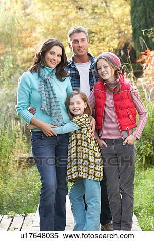 Stock Photography - Family Group Standing Outdoors On Wooden Walkway In Autumn Landscape. Fotosearch
