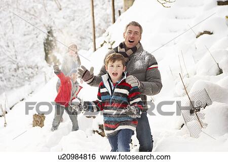Stock Photograph - Family Having Snowball Fight In Snowy Landscape. Fotosearch