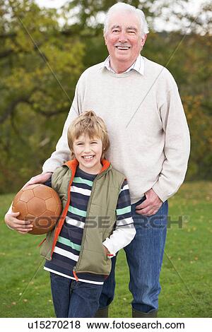 Grandfather With Grandson Holding Football Outside View Large Photo Image Stock Photo - Grandfather With Grandson Holding Football Outside. Fotosearch