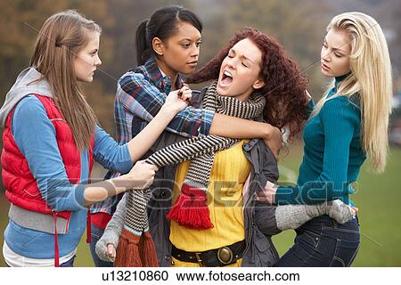 Stock Image - Group Of Female Teenagers Bullying Girl. Fotosearch