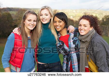 Stock Photograph - Group Of Four Teenage Female Friends In Autumn Landscape. Fotosearch