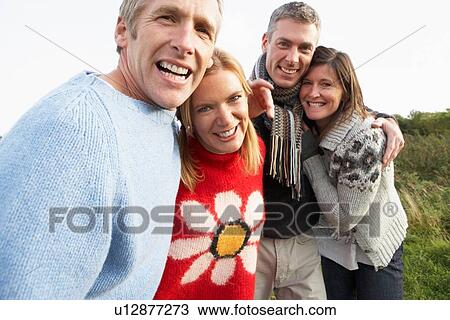 Stock Image - Group Of Friends On Walk In Autumn Countryside Together. Fotosearch