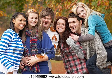 Stock Image - Group Of Six Teenage Friends Having Fun In Autumn Park. Fotosearch