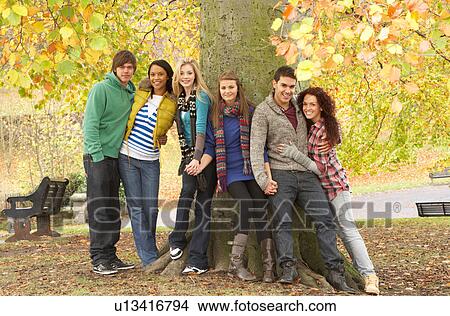 Group Of Six Teenage Friends Leaning Against Tree In Autumn Park View Large Photo Image Picture - Group Of Six Teenage Friends Leaning Against Tree In Autumn Park. Fotosearch