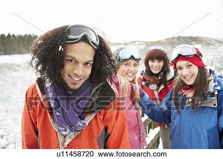 Stock Image - Group Of Teenage Friends Having Fun In Snowy Landscape Wearing Ski Clothing. Fotosearch