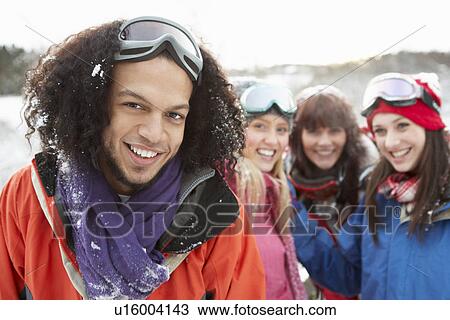 Stock Image - Group Of Teenage Friends Having Fun In Snowy Landscape Wearing Ski Clothing. Fotosearch