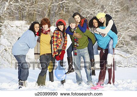 Stock Image - Group Of Teenage Friends Having Fun In Snowy Landscape. Fotosearch
