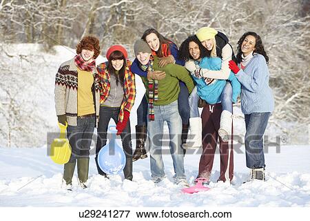 Stock Photo - Group Of Teenage Friends Having Fun In Snowy Landscape. Fotosearch