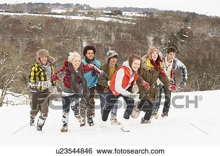 Stock Photograph - Group Of Teenage Friends Having Fun In Snowy Landscape. Fotosearch