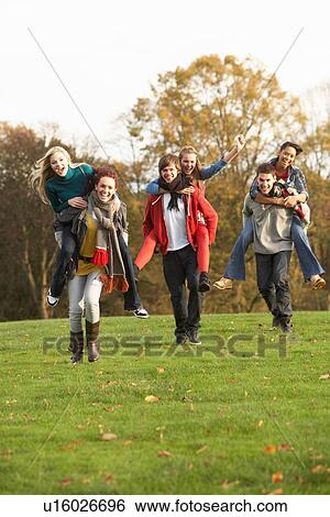 Group Of Teenage Friends Having Piggyback Rides In Autumn Landscape View Large Photo Image Stock Photograph - Group Of Teenage Friends Having Piggyback Rides In Autumn Landscape. Fotosearch
