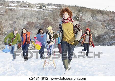 Group Of Teenage Friends Sledging In Snowy Landscape View Large Photo Image Stock Image - Group Of Teenage Friends Sledging In Snowy Landscape. Fotosearch