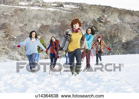 Group Of Teenage Friends Sledging In Snowy Landscape View Large Photo Image Stock Photo - Group Of Teenage Friends Sledging In Snowy Landscape. Fotosearch