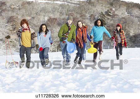 Group Of Teenage Friends Sledging In Snowy Landscape View Large Photo Image Stock Photograph - Group Of Teenage Friends Sledging In Snowy Landscape. Fotosearch