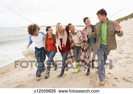 Group Of Young Friends Walking Along Autumn Shoreline View Large Photo Image Stock Photograph - Group Of Young Friends Walking Along Autumn Shoreline. Fotosearch