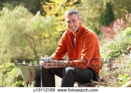Man Having Coffee Break Whilst Working Outdoors In Garden View Large Photo Image Stock Photo - Man Having Coffee Break Whilst Working Outdoors In Garden. Fotosearch