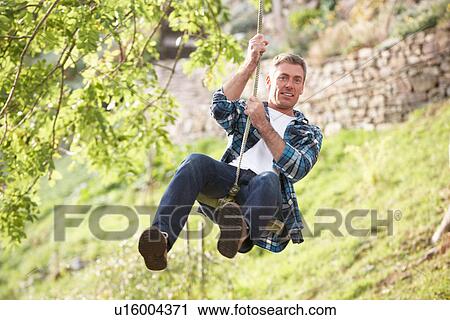 Man Having Fun On Woodland Swing In Autumn View Large Photo Image Stock Image - Man Having Fun On Woodland Swing In Autumn. Fotosearch