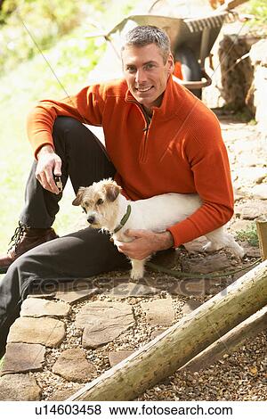 Man Outdoors With Dog Whilst On Break From Gardening View Large Photo Image Stock Photo - Man Outdoors With Dog Whilst On Break From Gardening. Fotosearch
