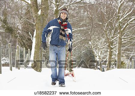 Stock Photo - Man Pulling Sledge Through Winter Landscape. Fotosearch