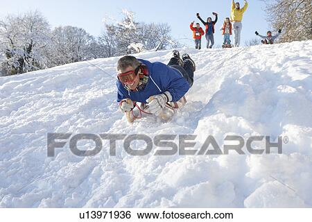 Man Sledging Down Hill With Family Watching View Large Photo Image Stock Photograph - Man Sledging Down Hill With Family Watching. Fotosearch