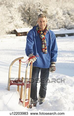 Middle Aged Man Standing In Snowy Landscape Holding Sledge View Large Photo Image Stock Image - Middle Aged Man Standing In Snowy Landscape Holding Sledge. Fotosearch