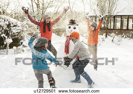 Mother And Children Building Snowman In Garden View Large Photo Image Stock Image - Mother And Children Building Snowman In Garden. Fotosearch
