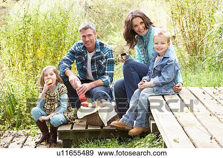 Stock Photo - Parents And Children Having Picnic In Countryside. Fotosearch