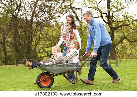Parents Giving Children Ride In Wheelbarrow View Large Photo Image Stock Image - Parents Giving Children Ride In Wheelbarrow. Fotosearch