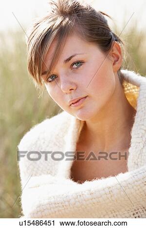 Stock Image - Portrait Of Beautiful Young Woman Relaxing On Beach. Fotosearch