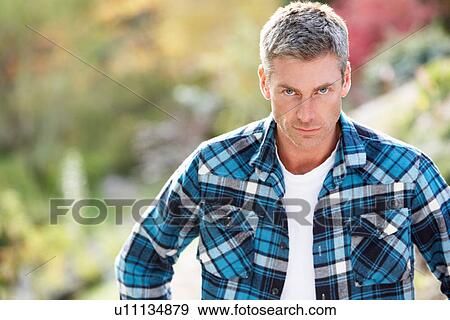 Stock Photo - Portrait Of Man Standing Outside In Autumn Landscape. Fotosearch