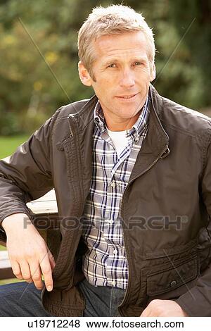 Stock Photo - Portrait Of Man Standing Outside In Autumn Landscape. Fotosearch