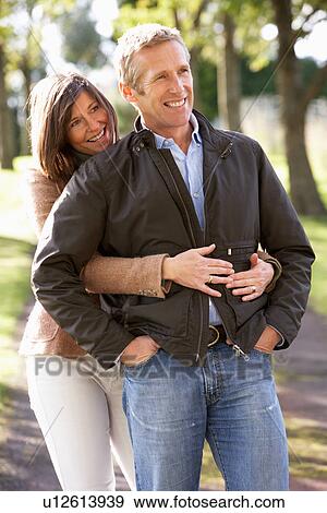 Portrait Of Romantic Couple Enjoying Outdoor Walk Through Autumn Park View Large Photo Image Stock Photo - Portrait Of Romantic Couple Enjoying Outdoor Walk Through Autumn Park. Fotosearch