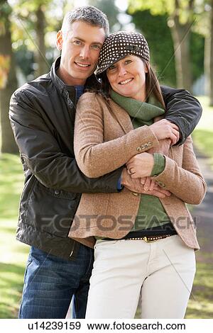 Stock Photo - Portrait Of Romantic Couple Enjoying Outdoor Walk Through Autumn Park. Fotosearch