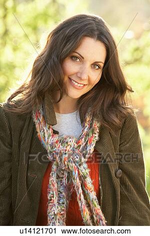 Stock Image - Portrait Of Woman Outdoors In Autumn Landscape. Fotosearch